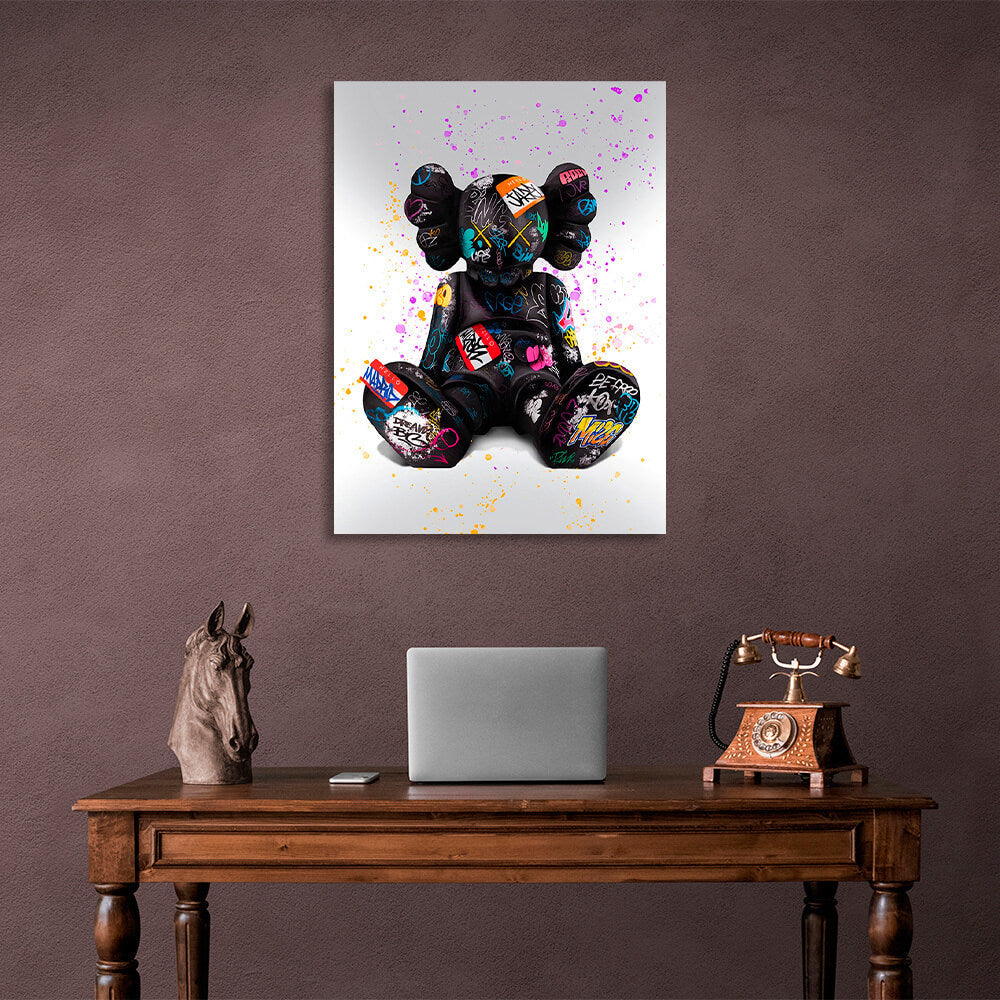 Schwarze Puppe auf grauem Hintergrund mit farbigen Flecken CANVAS Wand Kunstdruck