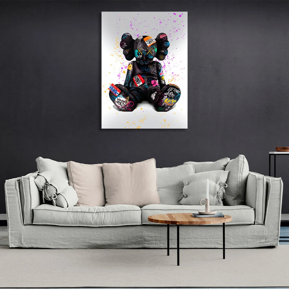 Schwarze Puppe auf grauem Hintergrund mit farbigen Flecken CANVAS Wand Kunstdruck