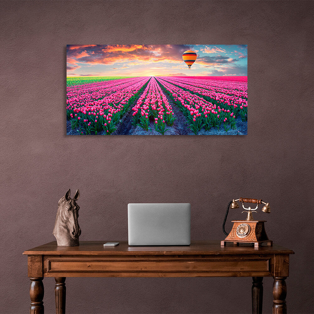 Ein Feld mit rosa Tulpen vor der Kulisse der Morgendämmerung und eines Heißluftballons auf Leinwand, Kunstdruck