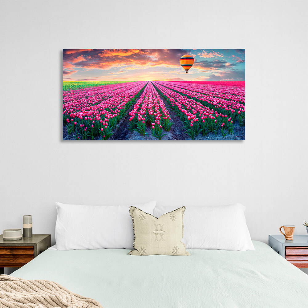 Ein Feld mit rosa Tulpen vor der Kulisse der Morgendämmerung und eines Heißluftballons auf Leinwand, Kunstdruck