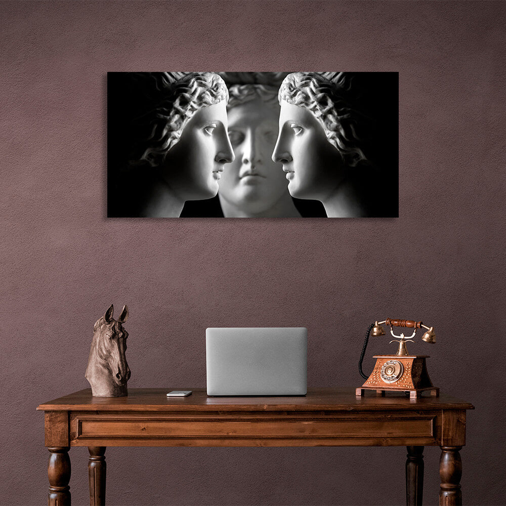 Three antique sculptures on a black background Canvas Wall Art Print