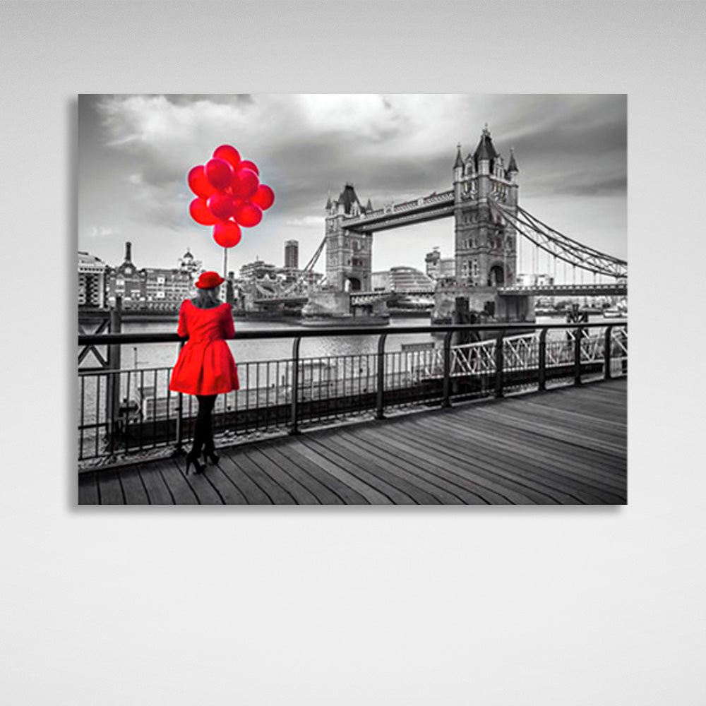 Leinwandbild „Eine Frau in einem roten Mantel und rote Luftballons im Hintergrund der London Bridge“