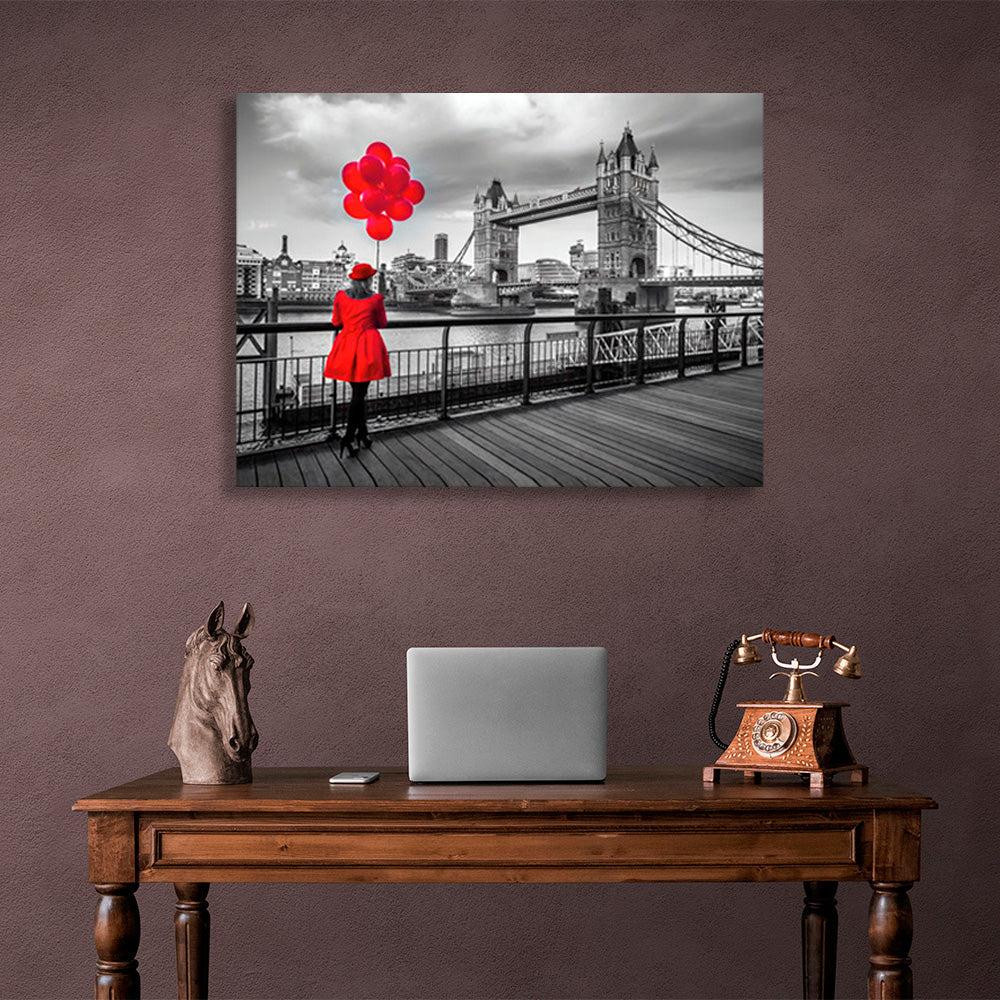 Leinwandbild „Eine Frau in einem roten Mantel und rote Luftballons im Hintergrund der London Bridge“