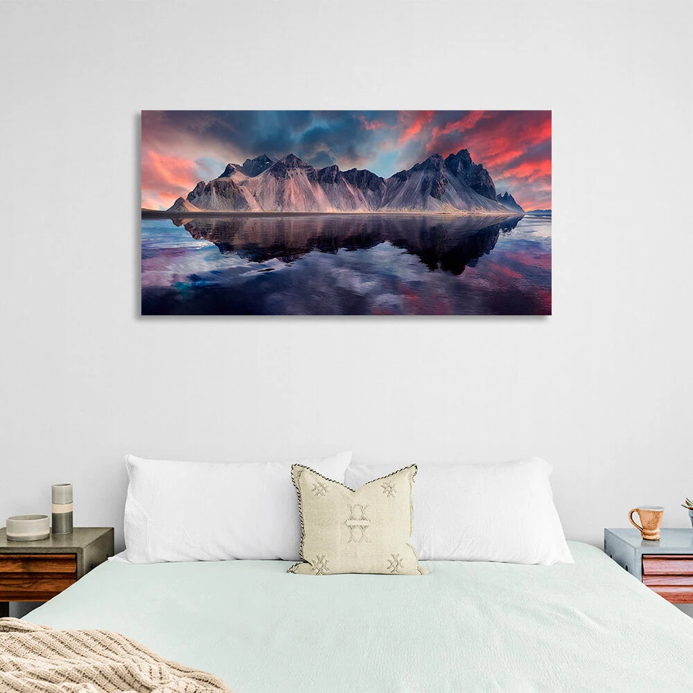 A rock in the sea against a red and blue sky Canvas Wall Art Print